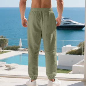 Back view of men's sage green linen jogger pants in a luxury beach resort setting