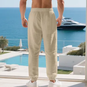 Back view of men's breathable sand-colored linen jogger pants in a resort beach setting