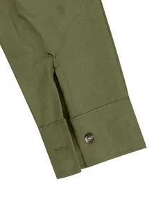 Detail view of men's olive green linen shirt cuff with a marbled button fastener