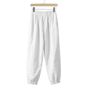 Close-up of white men's linen jogger pants with elastic waist and cuffs on a hanger