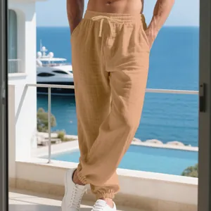 Detail view of men's beige linen joggers with drawstring waist in a resort setting