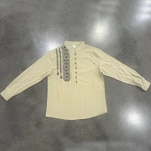 Detailed flat lay of a men's beige linen Henry shirt with intricate ethnic chest print
