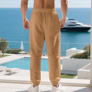Back view of premium men's sand colored linen jogger trousers for a beach vacation look.