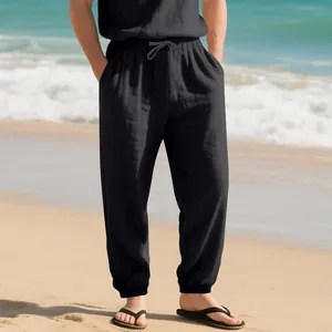 Breathable men's black cotton linen joggers styled in a relaxing summer beach setting