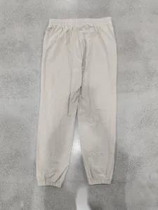 Close-up detail of men's casual beige linen joggers with elastic waist and cuffs