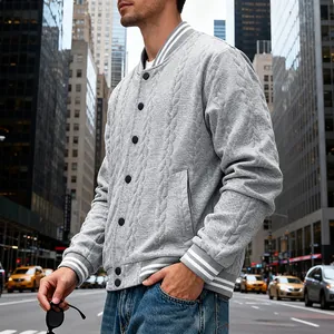 Close-up detail of a gray cable-knit bomber jacket featuring white striped cuffs