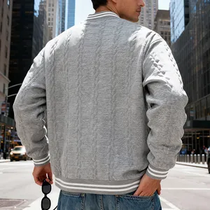 Back view of men's grey cable knit varsity bomber jacket in an urban street setting