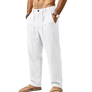 Detailed view of white loose linen trousers with drawstring waist shown on a male model