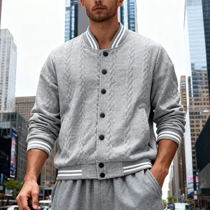 Close-up of a men's gray knitted varsity jacket with white striped ribbing and cable texture