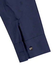 Close-up detail of a navy blue linen shirt cuff with button and fine stitching