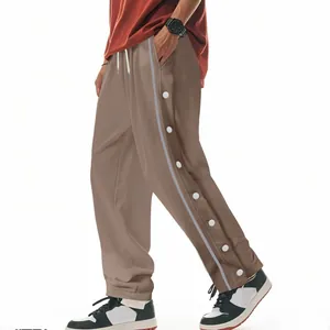 Vue détaillée du pantalon de basket marron avec boutons-pression blancs latéraux