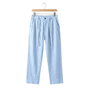 Front view of light blue men's loose linen trousers on a wooden hanger