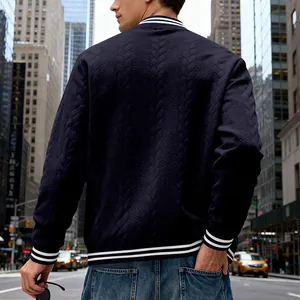 Close-up back view of a navy blue cable-knit bomber jacket for men on a city street