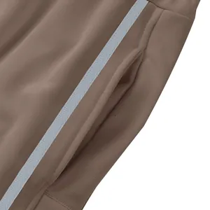 Gros plan de la poche latérale et de la bande sur un jogging marron lourd