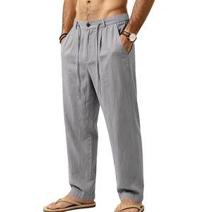 Detail of men's loose grey linen pants featuring drawstring waist and straight leg cut.