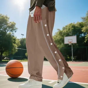 Vue détaillée du pantalon de basket marron à boutons-pression pour hommes sur terrain.