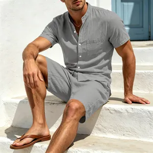 Lässiges graues Herren-Leinen-Set aus Henley-Hemd und Shorts auf weißen Treppen