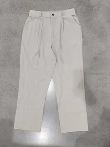 Front view of beige linen drawstring trousers with button closure and straight leg fit.