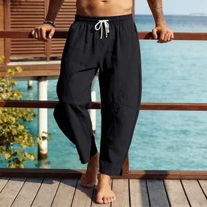 Vue détaillée d'un pantalon noir ample pour homme avec cordon de serrage au bord de mer.