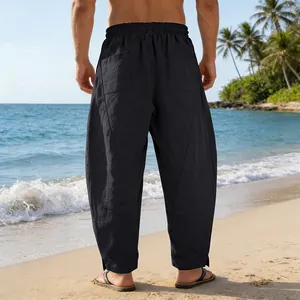 Vue arrière d'un pantalon patchwork large pour homme style hip-hop sur une plage ensoleillée.