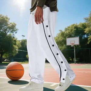 Vue détaillée du pantalon de basket blanc pour homme avec boutons latéraux sur terrain