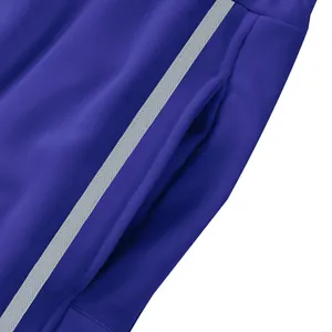 Gros plan sur la poche latérale et la bande décorative du pantalon de sport bleu pour hommes