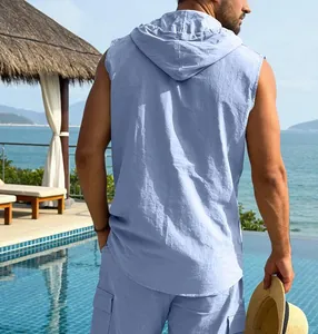 Back view of men's light blue sleeveless linen hooded shirt in a resort setting
