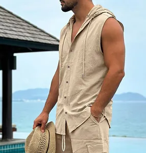 Detailed side view of a man wearing a beige linen sleeveless hooded shirt by the sea.