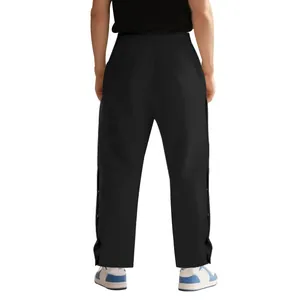 Vue arrière d'un pantalon de sport noir avec boutons-pression latéraux style hip-hop
