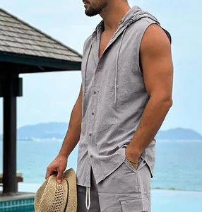 Close-up of a grey sleeveless hooded linen shirt worn in a tropical beach resort setting