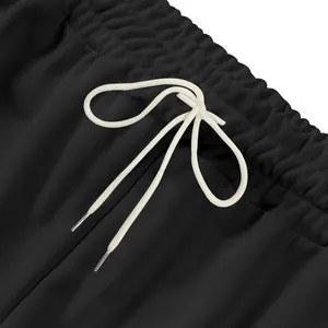 Gros plan d'un jogging noir avec taille élastiquée et cordon de serrage blanc noué.