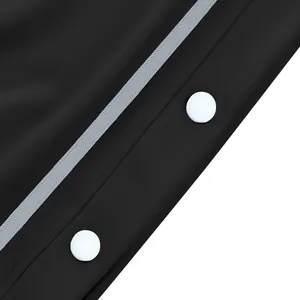 Détail des boutons-pression latéraux et de la bande sur le pantalon de sport noir déchirable