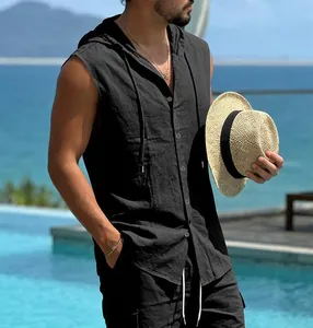 Detail view of men's black linen hooded sleeveless shirt at a beach resort setting