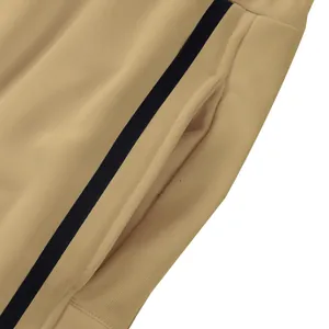 Gros plan détaillé d'un pantalon de survêtement kaki pour homme avec poche latérale et rayure