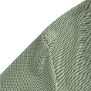 Detailed close-up showing the breathable mesh fabric texture and shoulder seam of a green polo shirt