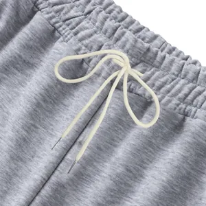 Gros plan de la taille élastique et du cordon blanc sur un jogging gris très épais