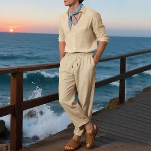 Full body shot of a man wearing a beige linen suit set on a scenic beach boardwalk