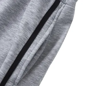 Gros plan de la poche et de la bande latérale noire sur un jogging gris