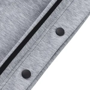 Détail de la fermeture à bouton-pression sur un pantalon de basket gris chiné