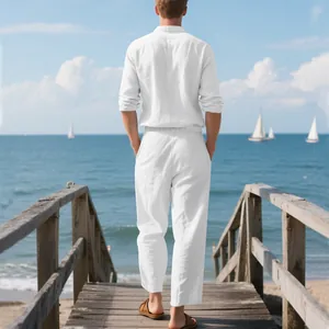 Back view of a man wearing a white linen shirt and trousers set on a wooden pier