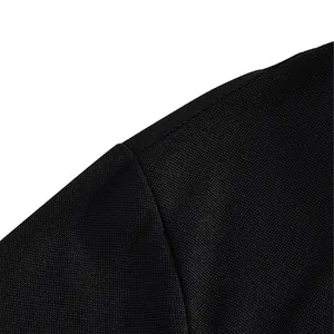 Close-up of breathable quick-dry fabric on a men's black polo shirt shoulder seam.