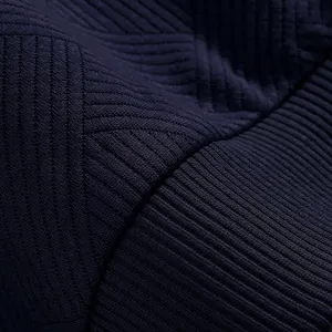 Macro detail of navy blue heavy knit sweatshirt fabric with textured jacquard pattern
