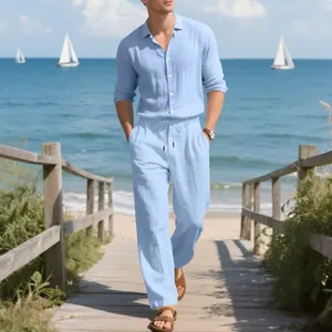 Detail of men's light blue linen shirt and trousers set worn in a beach setting