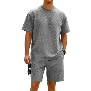 Detail eines grau strukturierten karierten Herren-Freizeit-Sets mit T-Shirt und Shorts