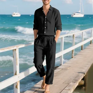Detailed view of a man wearing a black linen shirt and pants set on a seaside pier.