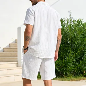 Back view of a man wearing a white and blue striped linen short sleeve shirt and shorts set