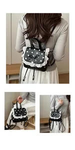 Dettaglio di un grazioso zaino nero a pois con bordo in pizzo e fiocco decorativo