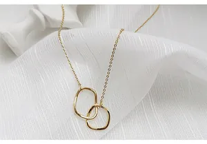 Vue détaillée d'un collier doré minimaliste avec des pendentifs carrés imbriqués