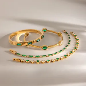 Detalle de pulseras bañadas en oro de 18 quilates con circonitas verdes.