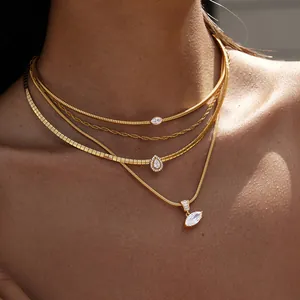 Detailed close-up of stacked gold titanium steel necklaces with sparkling crystal pendants.